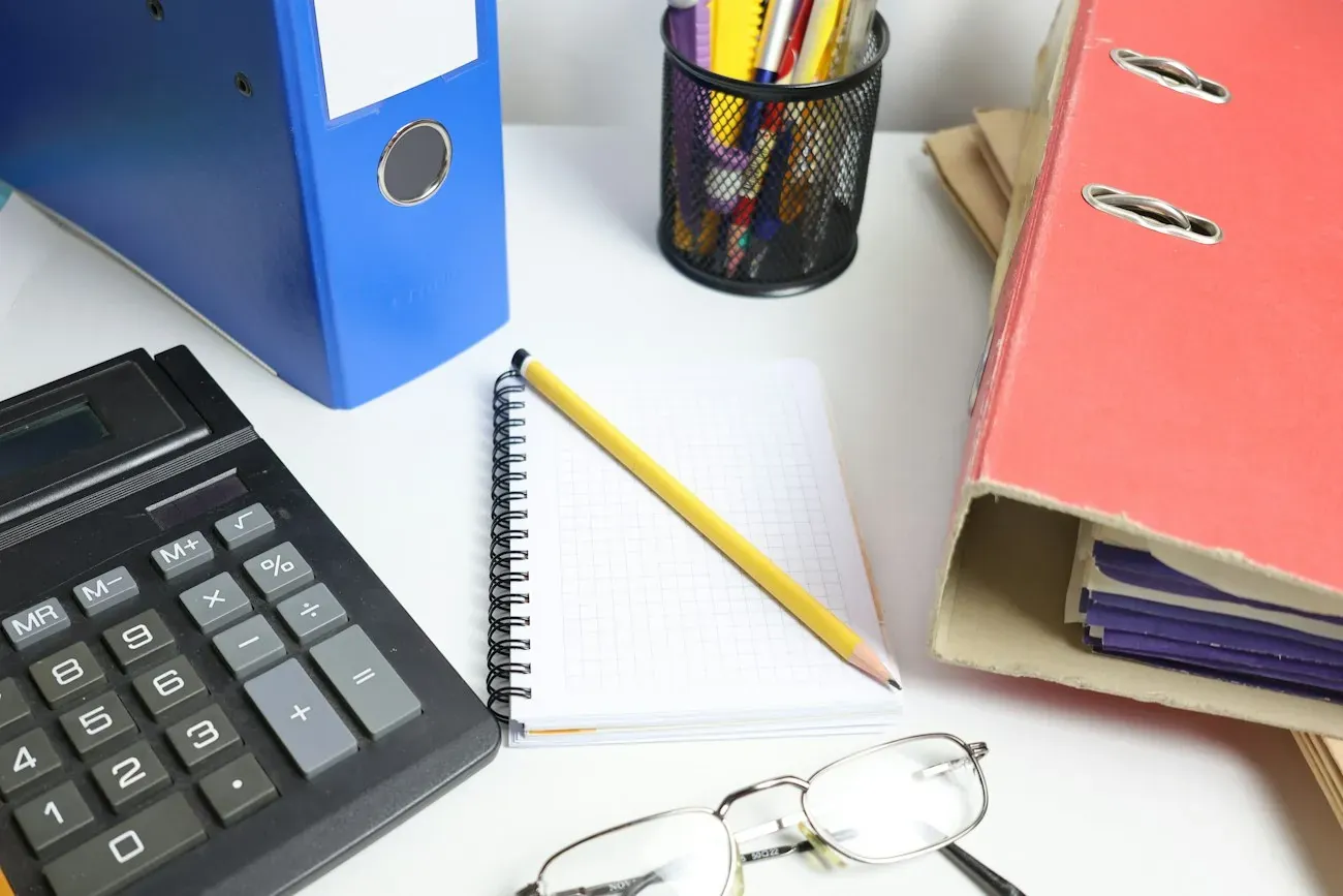 Documents, binders and glasses on a desk